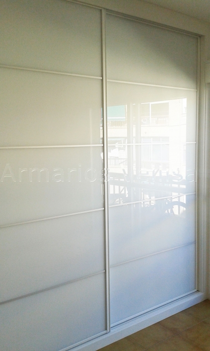 Armario a medida 2 puertas correderas. Modelo: Panel Japonés con cristal blanco separado en 5 partes con 4 junquillos aluminio mate. Color base: Blanco melamina. Color paneles: Cristal Blanco