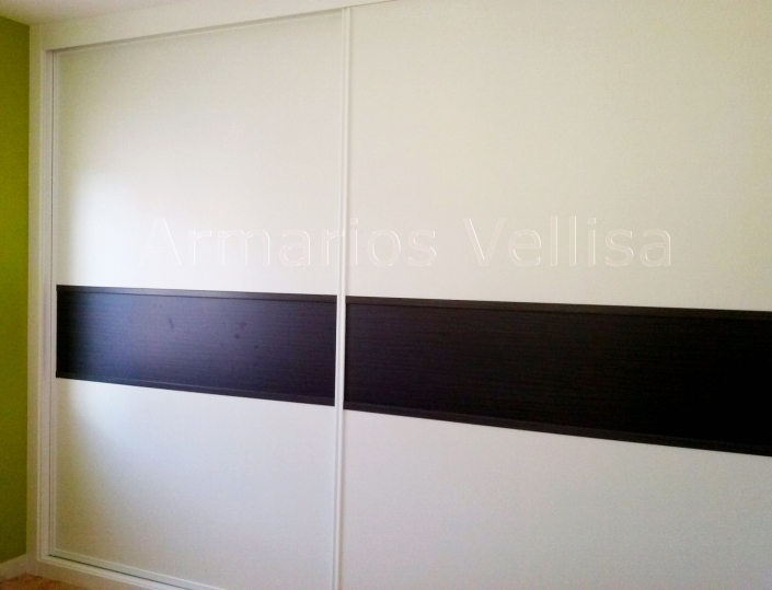 Armario empotrado en habitación. 2,70 X 3,49 X 0,67 Puertas correderas: 2 Modelo Franja horizontal, 40 cm. altura, separada por junquillos DM blancos. Color base: Blanco, melamina. Color franja: Ceniza