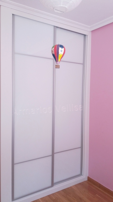 Armario a medida 2 puertas correderas con dos junquillos de aluminio mate, separados entre ellos 3/5 partes. Y enmarcado puertas aluminio mate, resto; cristal blanco con molduras en blanco, melamina